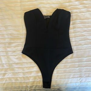 Never worn blue blush low cut black body suit. size small.
